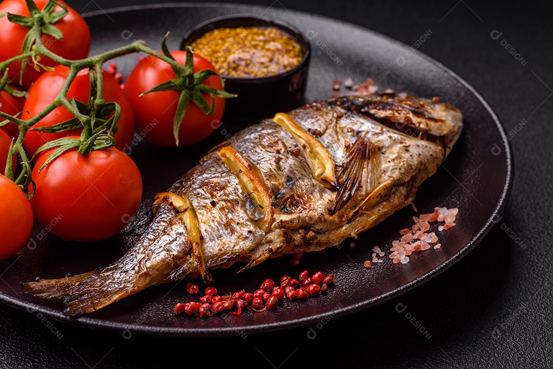 Delicioso dorado assado na grelha com sal, especiarias e ervas sobre um fundo escuro texturizado