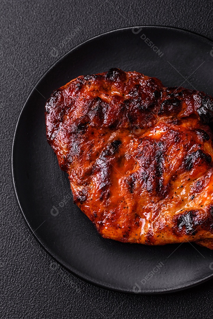 Bife fresco, suculento e delicioso em um fundo escuro. Prato de carne com especiarias e ervas