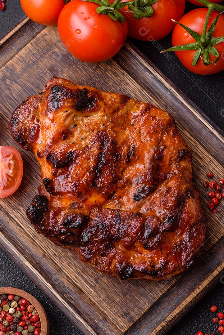 Bife fresco, suculento e delicioso em um fundo escuro. Prato de carne com especiarias e ervas