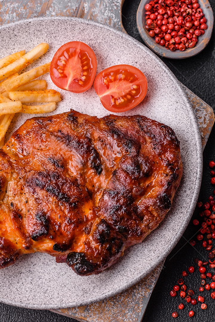 Bife fresco, suculento e delicioso em um fundo escuro. Prato de carne com especiarias e ervas