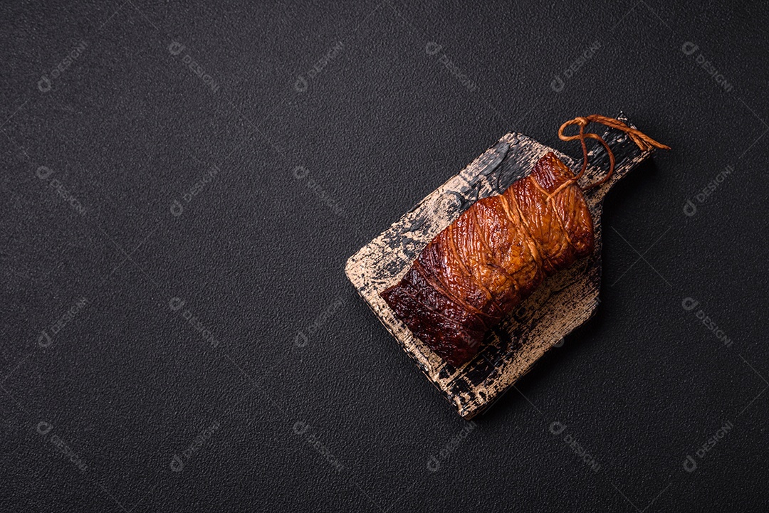 Delicioso peito de frango de carne defumada com sal, especiarias e ervas sobre um fundo escuro de concreto