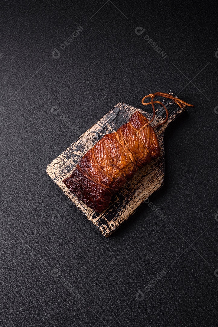 Delicioso peito de frango de carne defumada com sal, especiarias e ervas sobre um fundo escuro de concreto