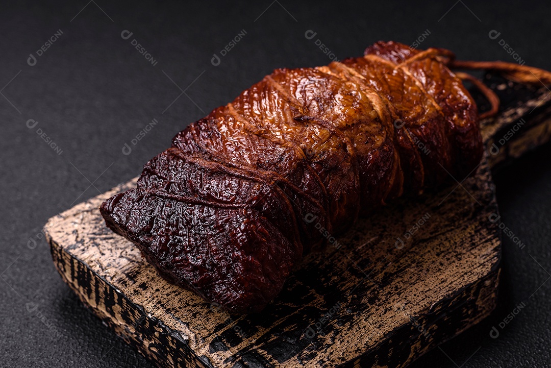 Delicioso peito de frango de carne defumada com sal, especiarias e ervas sobre um fundo escuro de concreto