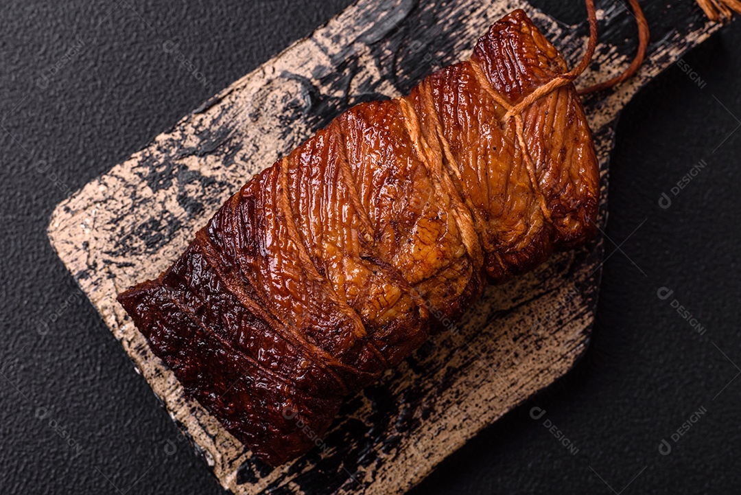 Delicioso peito de frango de carne defumada com sal, especiarias e ervas sobre um fundo escuro de concreto