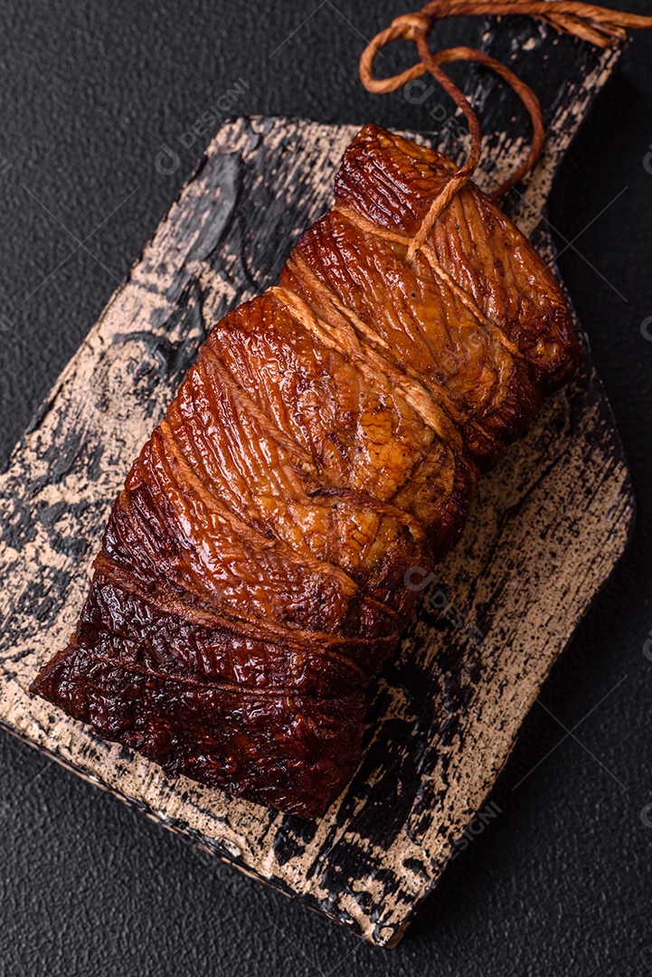 Delicioso peito de frango de carne defumada com sal, especiarias e ervas sobre um fundo escuro de concreto