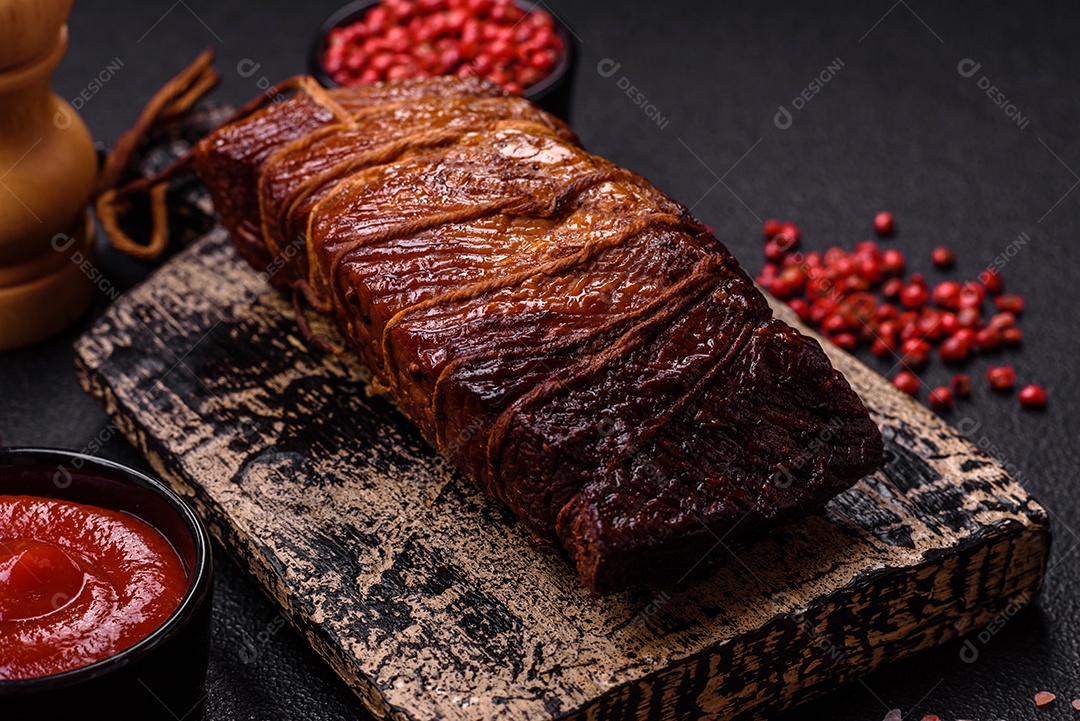 Delicioso peito de frango de carne defumada com sal, especiarias e ervas sobre um fundo escuro de concreto