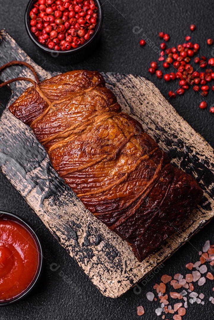 Delicioso peito de frango de carne defumada com sal, especiarias e ervas sobre um fundo escuro de concreto