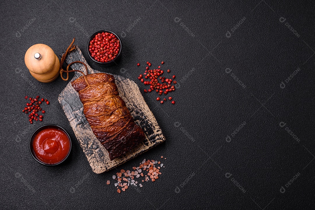 Delicioso peito de frango de carne defumada com sal, especiarias e ervas sobre um fundo escuro de concreto