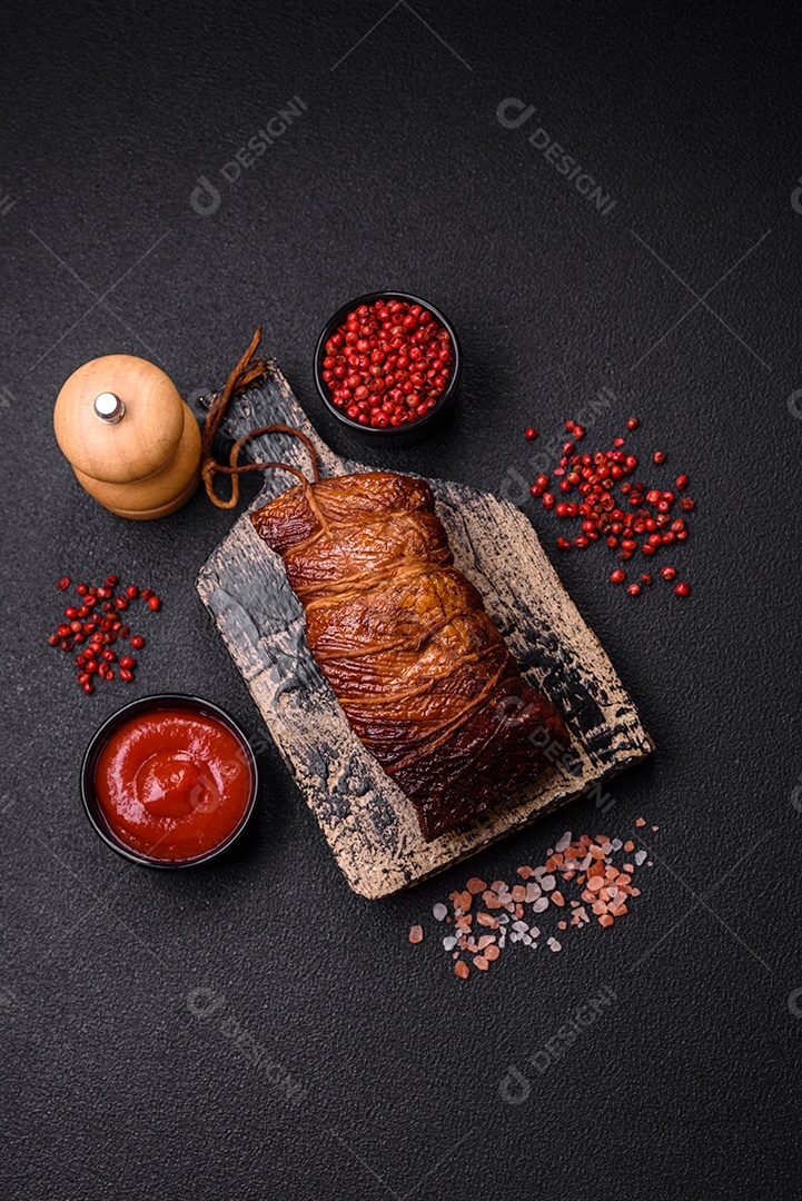 Delicioso peito de frango de carne defumada com sal, especiarias e ervas sobre um fundo escuro de concreto