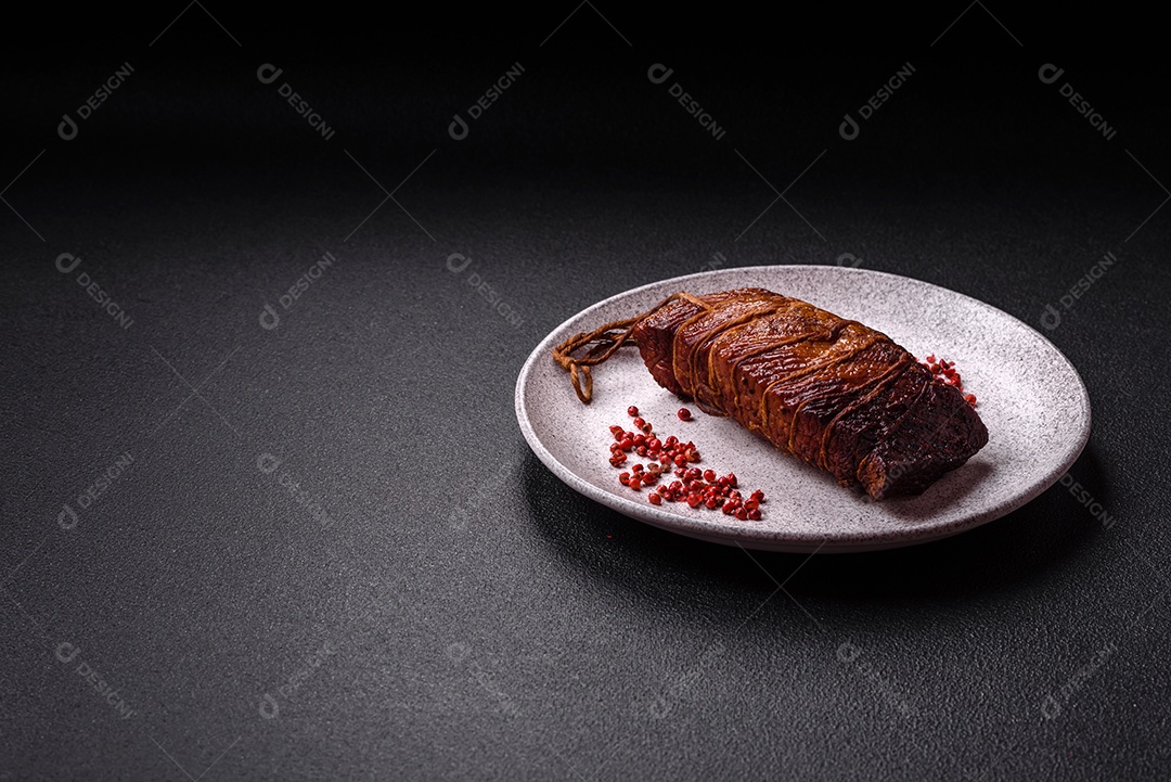 Delicioso peito de frango de carne defumada com sal, especiarias e ervas sobre um fundo escuro de concreto
