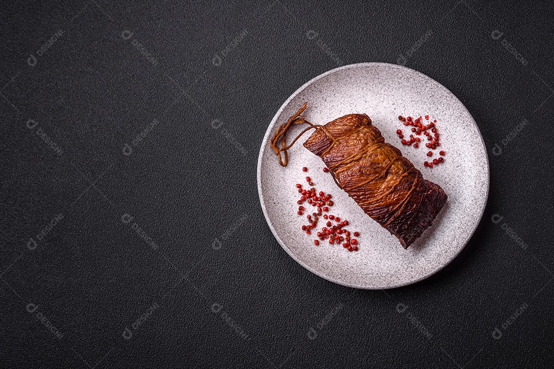 Delicioso peito de frango de carne defumada com sal, especiarias e ervas sobre um fundo escuro de concreto