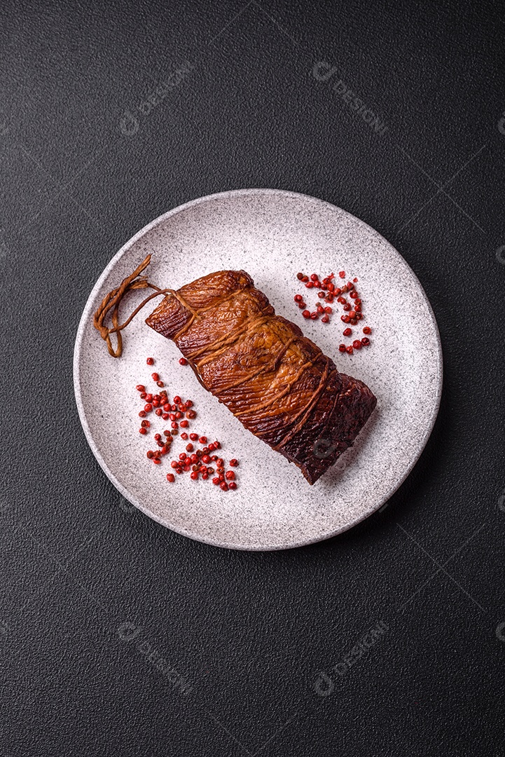 Delicioso peito de frango de carne defumada com sal, especiarias e ervas sobre um fundo escuro de concreto