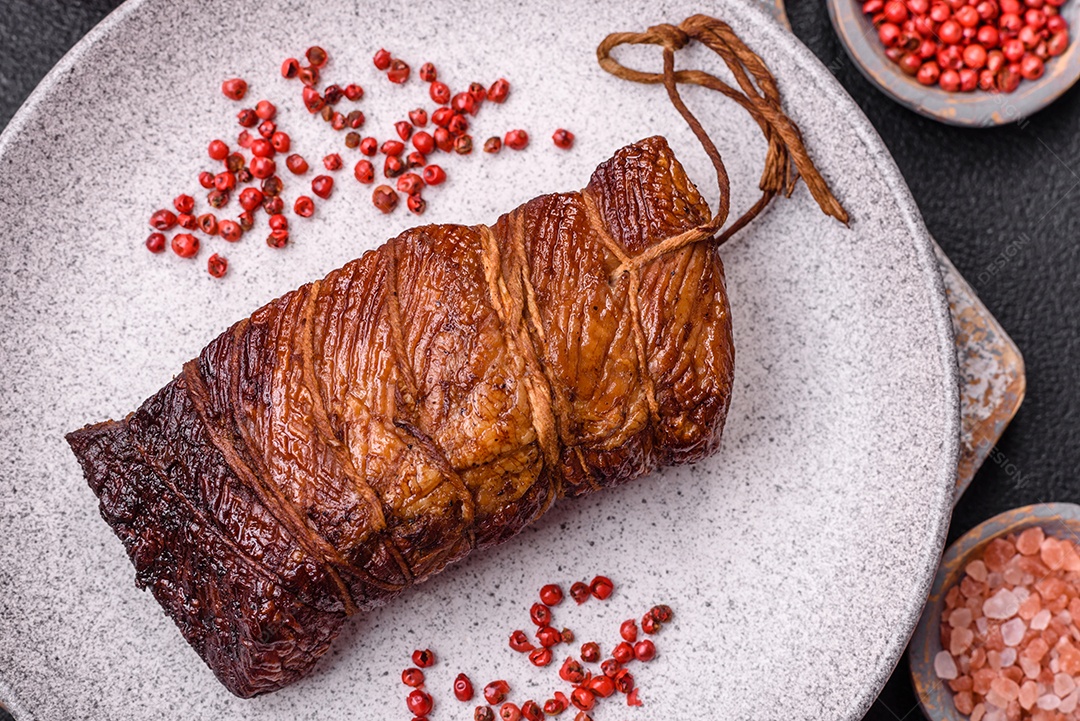 Delicioso peito de frango de carne defumada com sal, especiarias e ervas sobre um fundo escuro de concreto