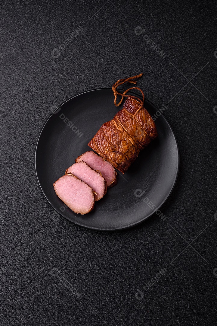 Delicioso peito de frango de carne defumada com sal, especiarias e ervas sobre um fundo escuro de concreto