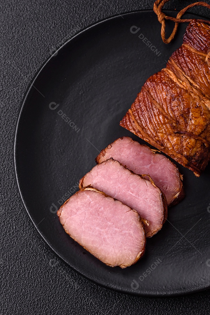 Delicioso peito de frango de carne defumada com sal, especiarias e ervas sobre um fundo escuro de concreto