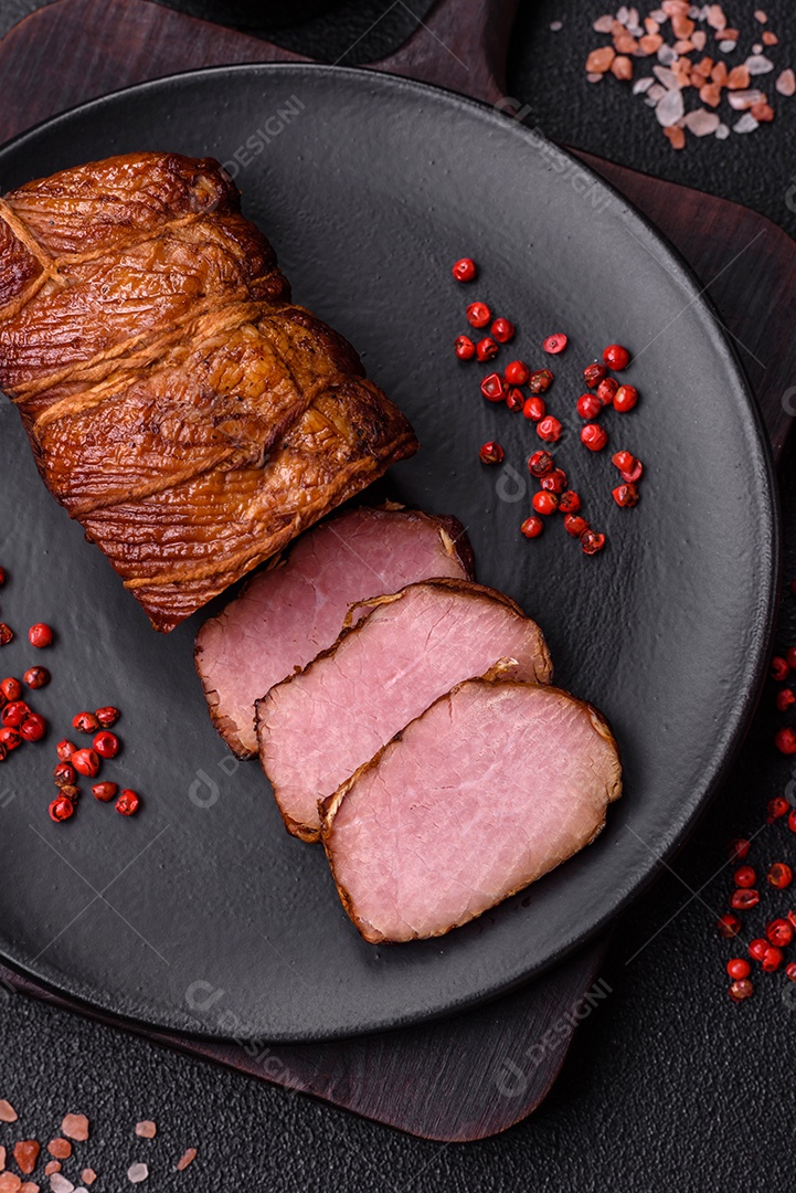 Delicioso peito de frango de carne defumada com sal, especiarias e ervas sobre um fundo escuro de concreto