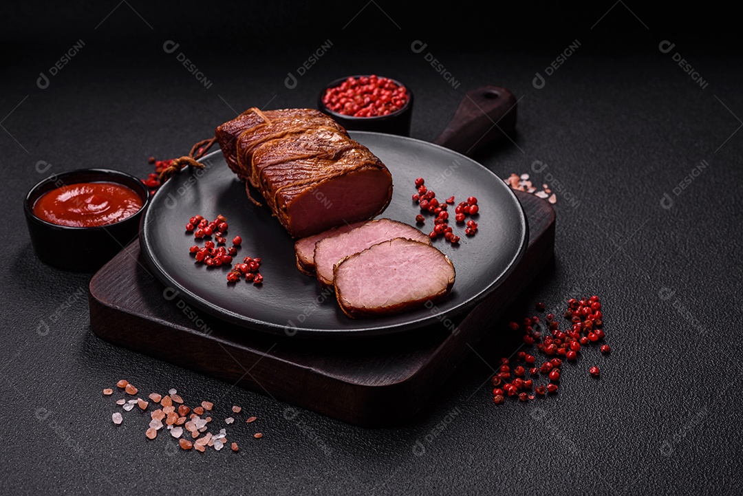 Delicioso peito de frango de carne defumada com sal, especiarias e ervas sobre um fundo escuro de concreto