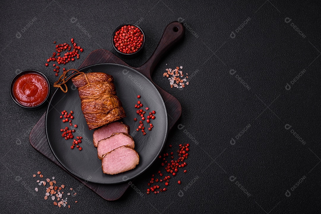 Delicioso peito de frango de carne defumada com sal, especiarias e ervas sobre um fundo escuro de concreto