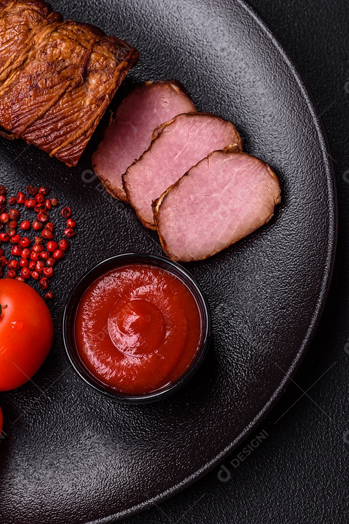Delicioso peito de frango de carne defumada com sal, especiarias e ervas sobre um fundo escuro de concreto