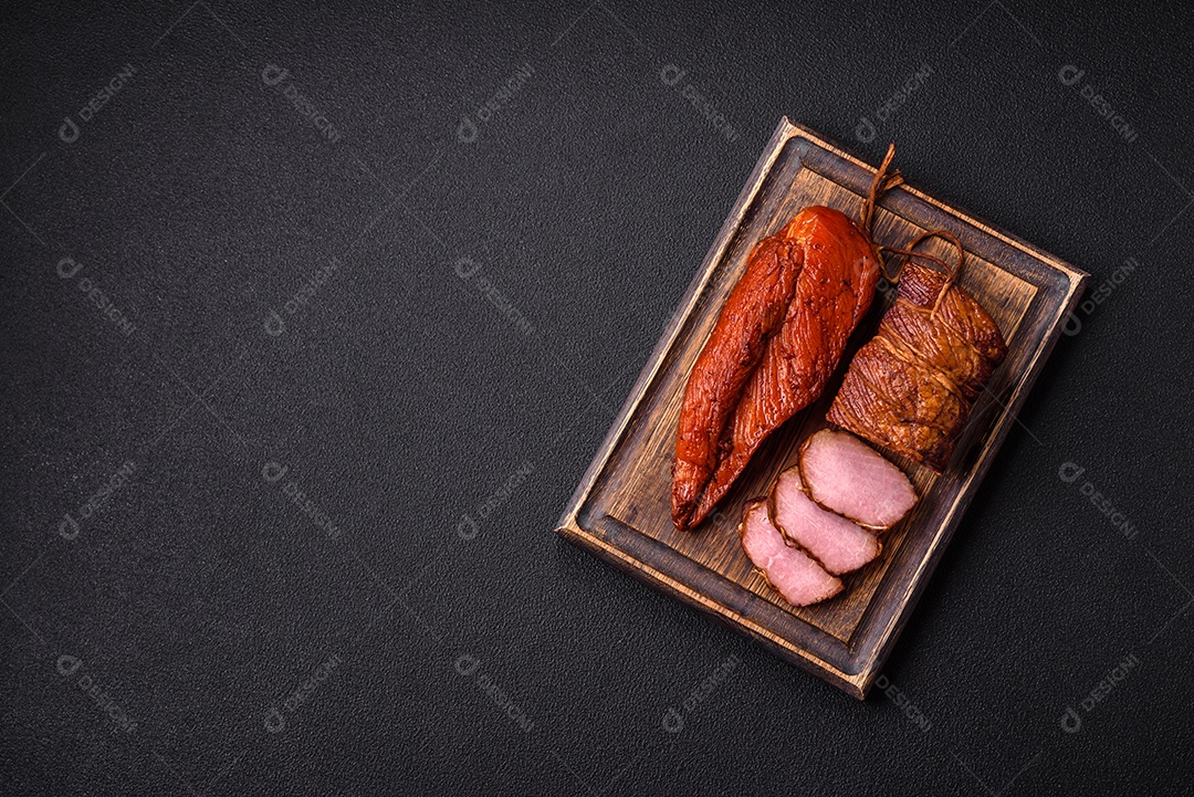 Delicioso peito de frango de carne defumada com sal, especiarias e ervas sobre um fundo escuro de concreto