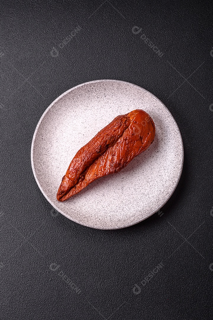 Delicioso peito de frango de carne defumada com sal, especiarias e ervas sobre um fundo escuro de concreto