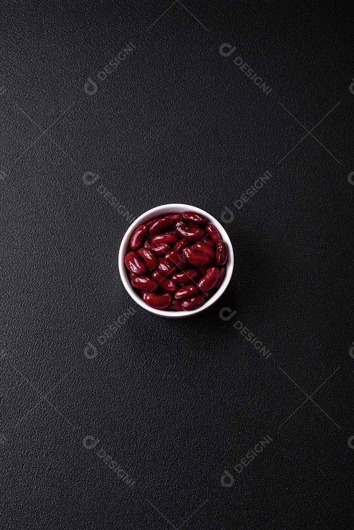 Feijão vermelho enlatado com sal e especiarias numa tigela branca como ingrediente para fazer um pequeno-almoço saudável