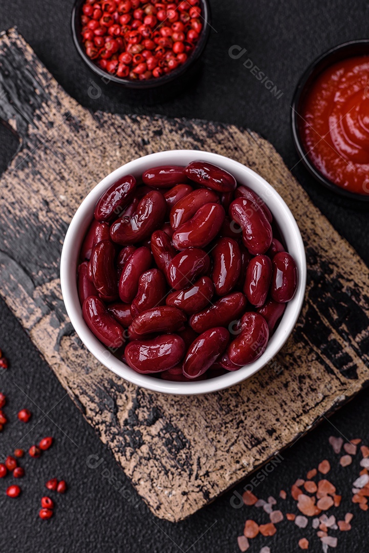 Feijão vermelho enlatado com sal e especiarias numa tigela branca como ingrediente para fazer um pequeno-almoço saudável