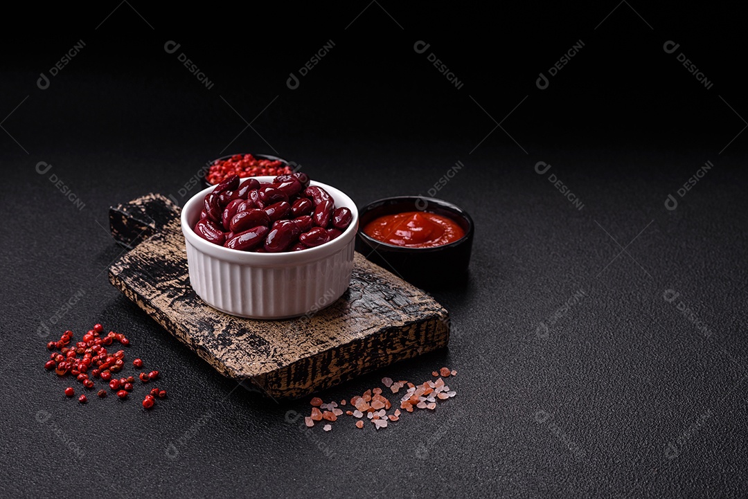 Feijão vermelho enlatado com sal e especiarias numa tigela branca como ingrediente para fazer um pequeno-almoço saudável