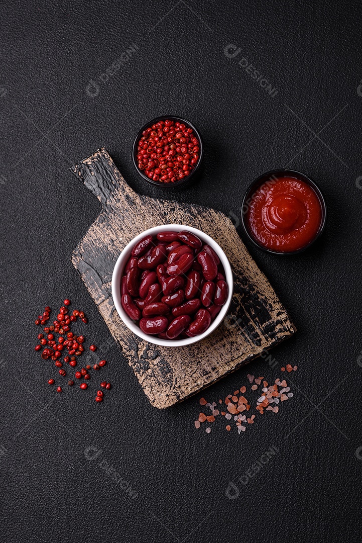 Feijão vermelho enlatado com sal e especiarias numa tigela branca como ingrediente para fazer um pequeno-almoço saudável