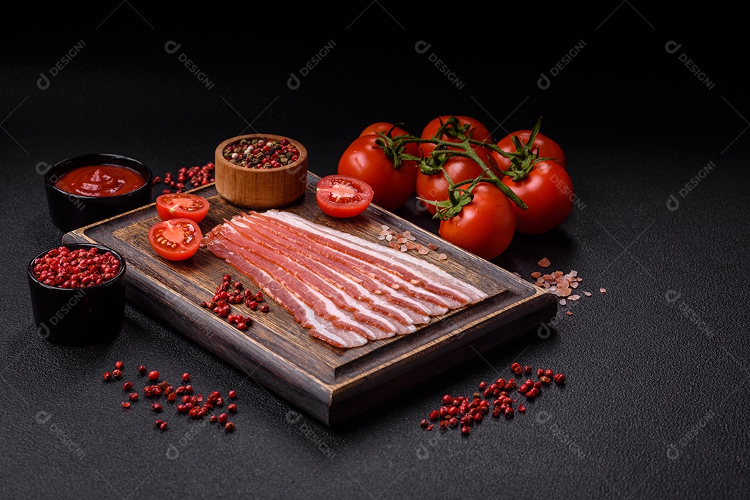 Delicioso bacon frito fresco com sal e especiarias sobre fundo escuro como ingrediente para preparar um farto café da manhã