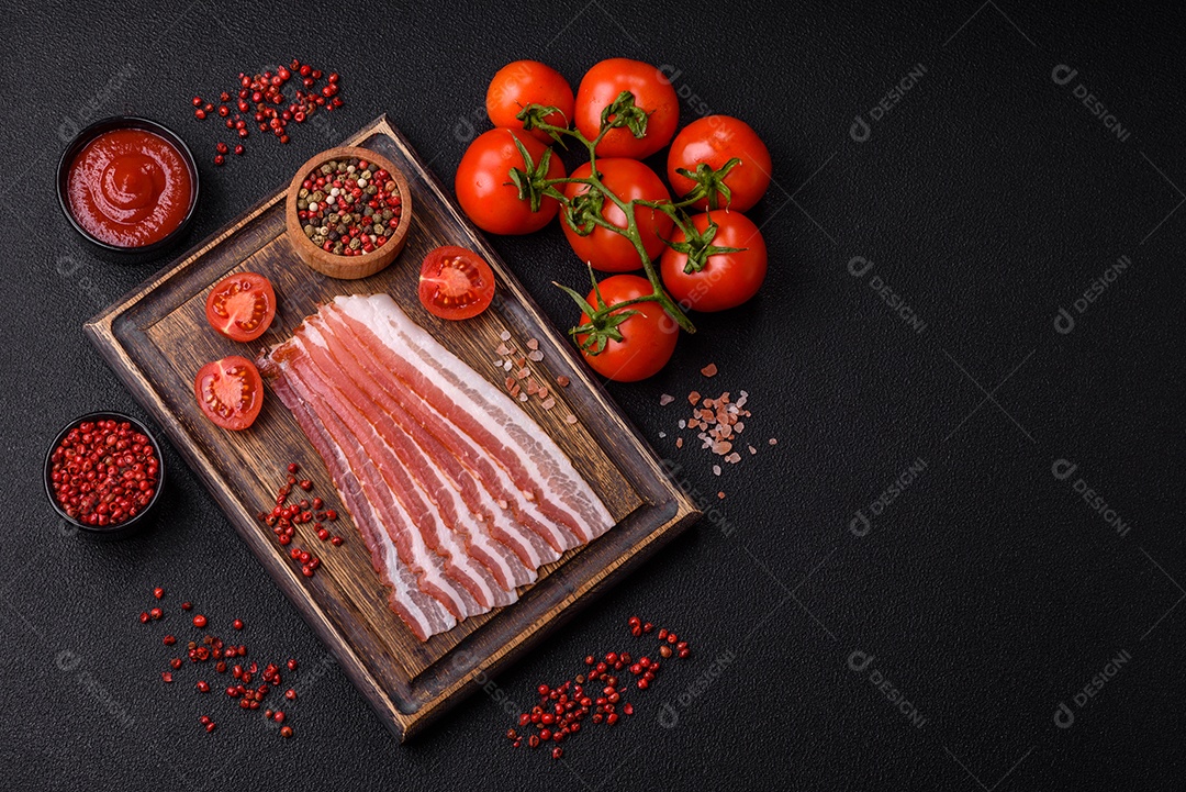 Delicioso bacon frito fresco com sal e especiarias sobre fundo escuro como ingrediente para preparar um farto café da manhã