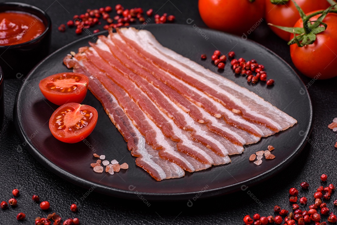 Delicioso bacon frito fresco com sal e especiarias sobre fundo escuro como ingrediente para preparar um farto café da manhã