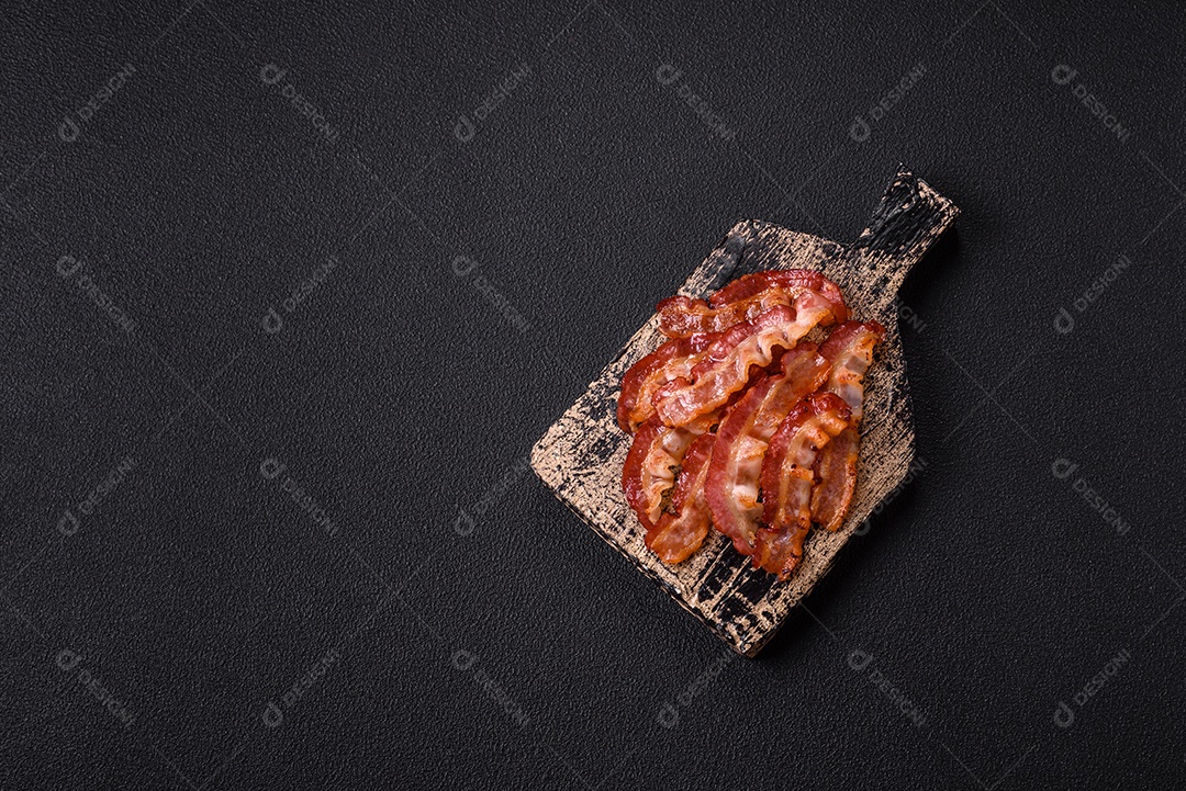 Delicioso bacon frito fresco com sal e especiarias sobre fundo escuro como ingrediente para preparar um farto café da manhã