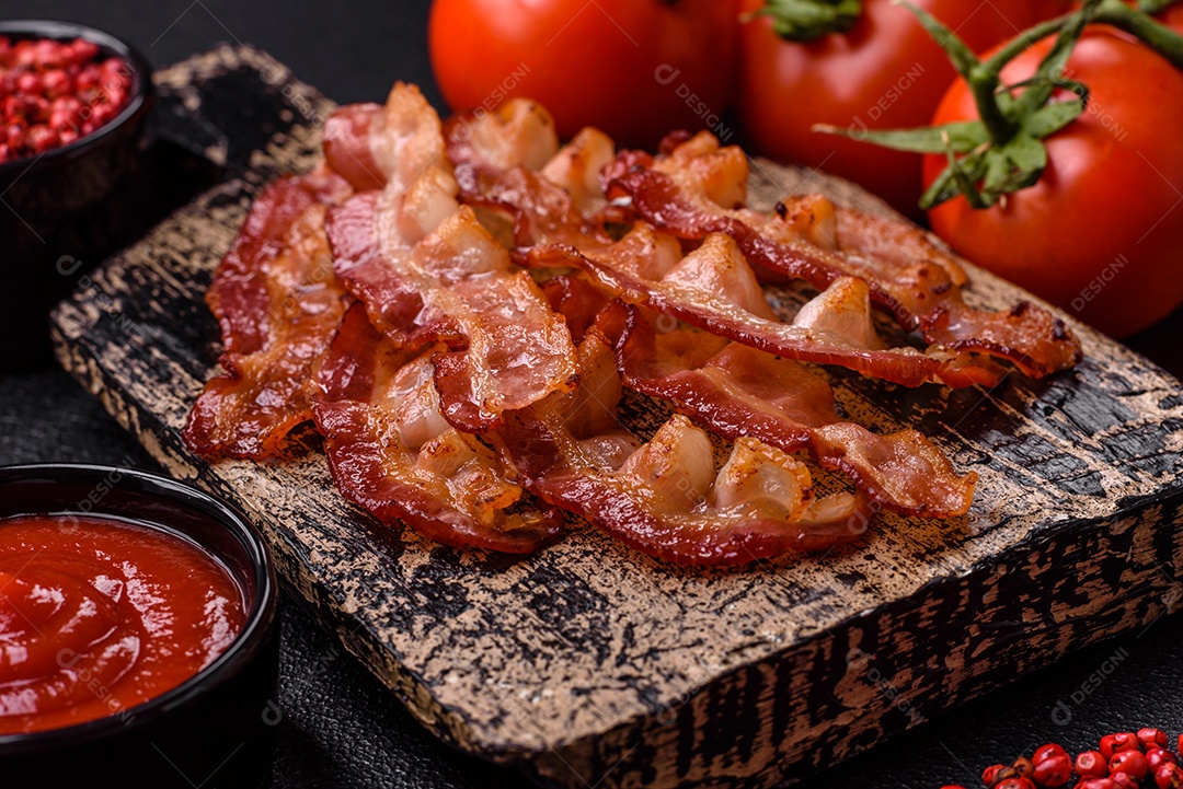 Delicioso bacon frito fresco com sal e especiarias sobre fundo escuro como ingrediente para preparar um farto café da manhã