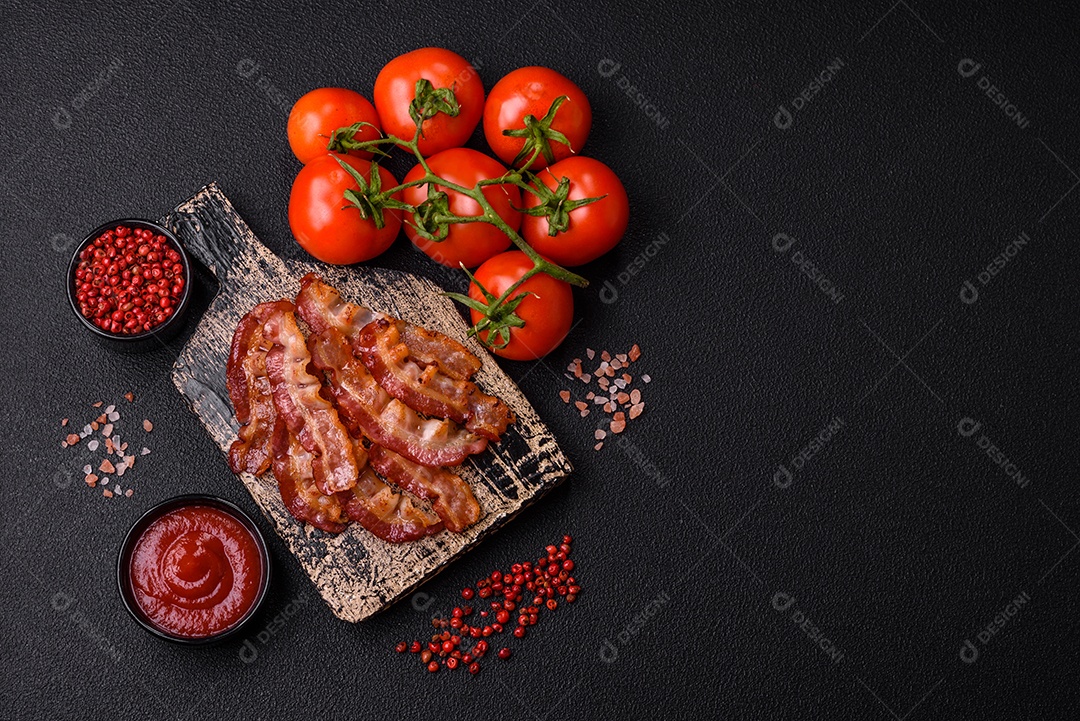 Delicioso bacon frito fresco com sal e especiarias sobre fundo escuro como ingrediente para preparar um farto café da manhã