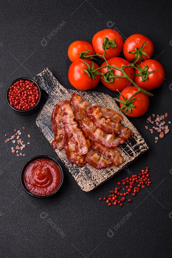 Delicioso bacon frito fresco com sal e especiarias sobre fundo escuro como ingrediente para preparar um farto café da manhã