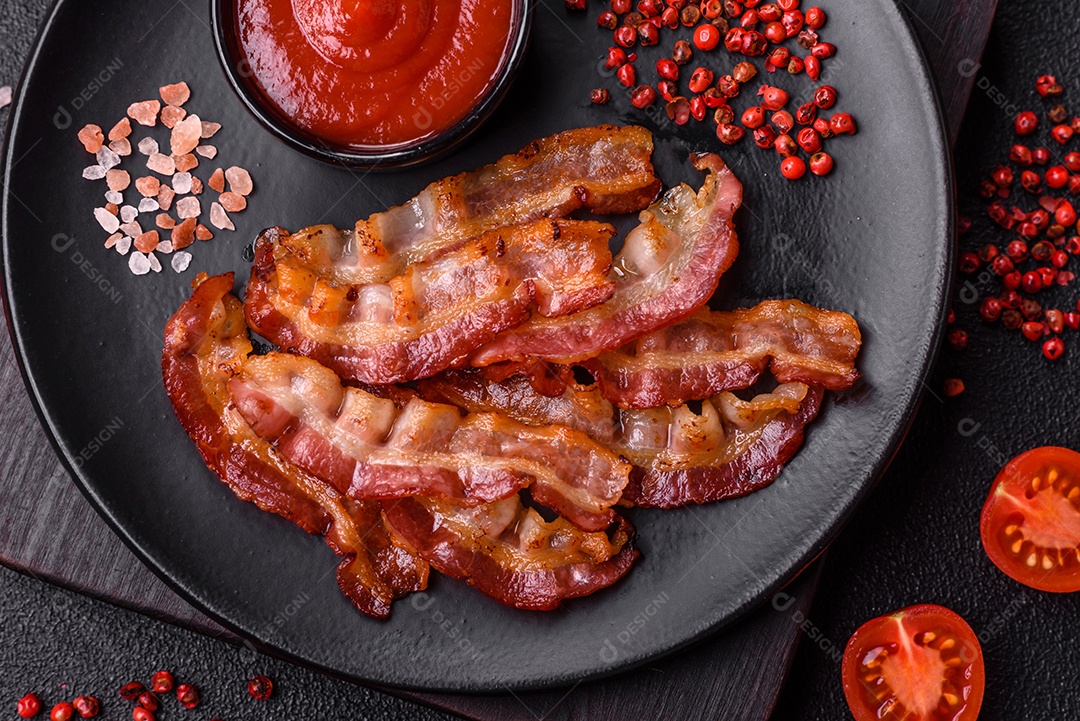 Delicioso bacon frito fresco com sal e especiarias sobre fundo escuro como ingrediente para preparar um farto café da manhã