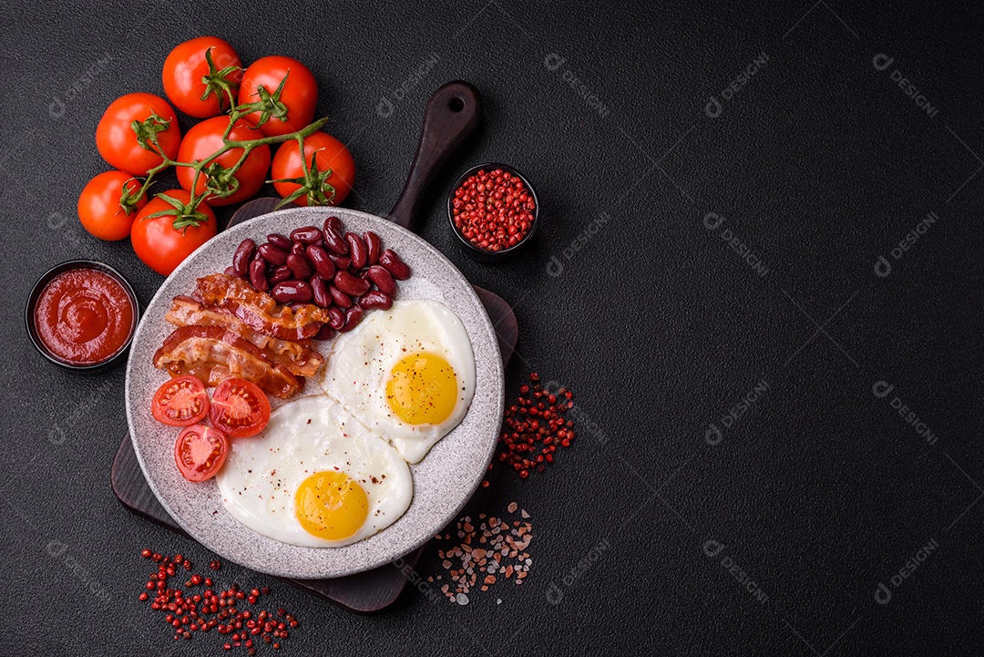 Café da manhã inglês com ovos fritos, bacon, feijão, tomate, especiarias e ervas. Um início de dia saudável e nutritivo