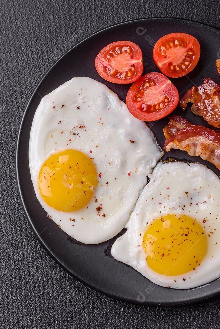 Café da manhã inglês com ovos fritos, bacon, feijão, tomate, especiarias e ervas. Um início de dia saudável e nutritivo