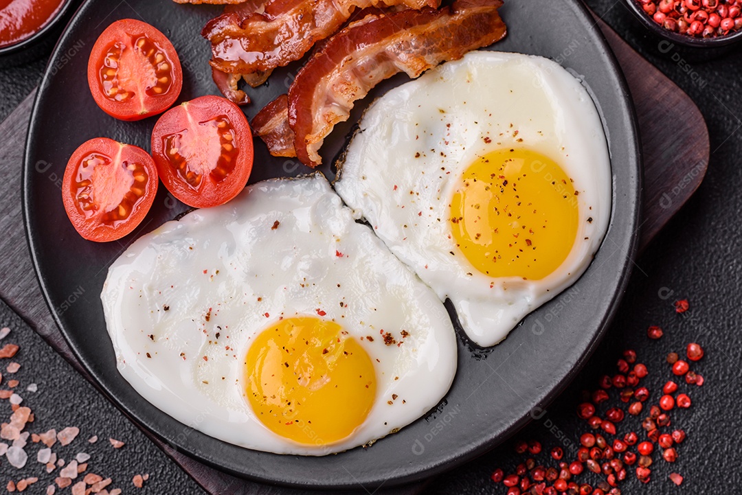 Café da manhã inglês com ovos fritos, bacon, feijão, tomate, especiarias e ervas. Um início de dia saudável e nutritivo