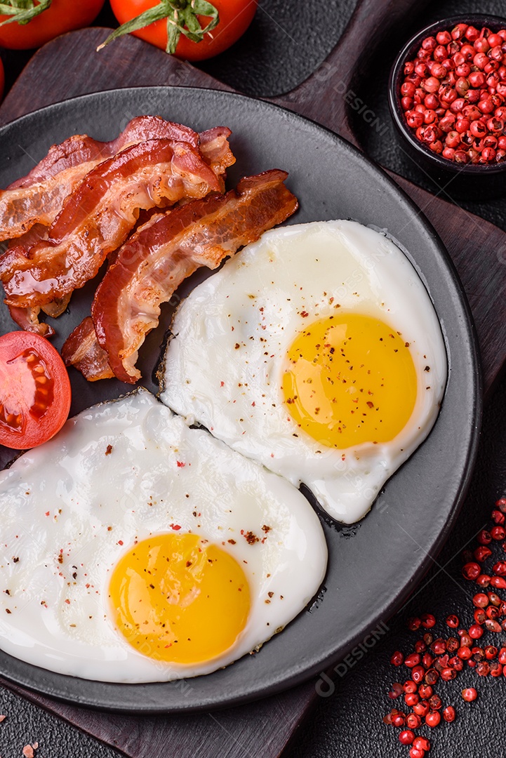 Café da manhã inglês com ovos fritos, bacon, feijão, tomate, especiarias e ervas. Um início de dia saudável e nutritivo