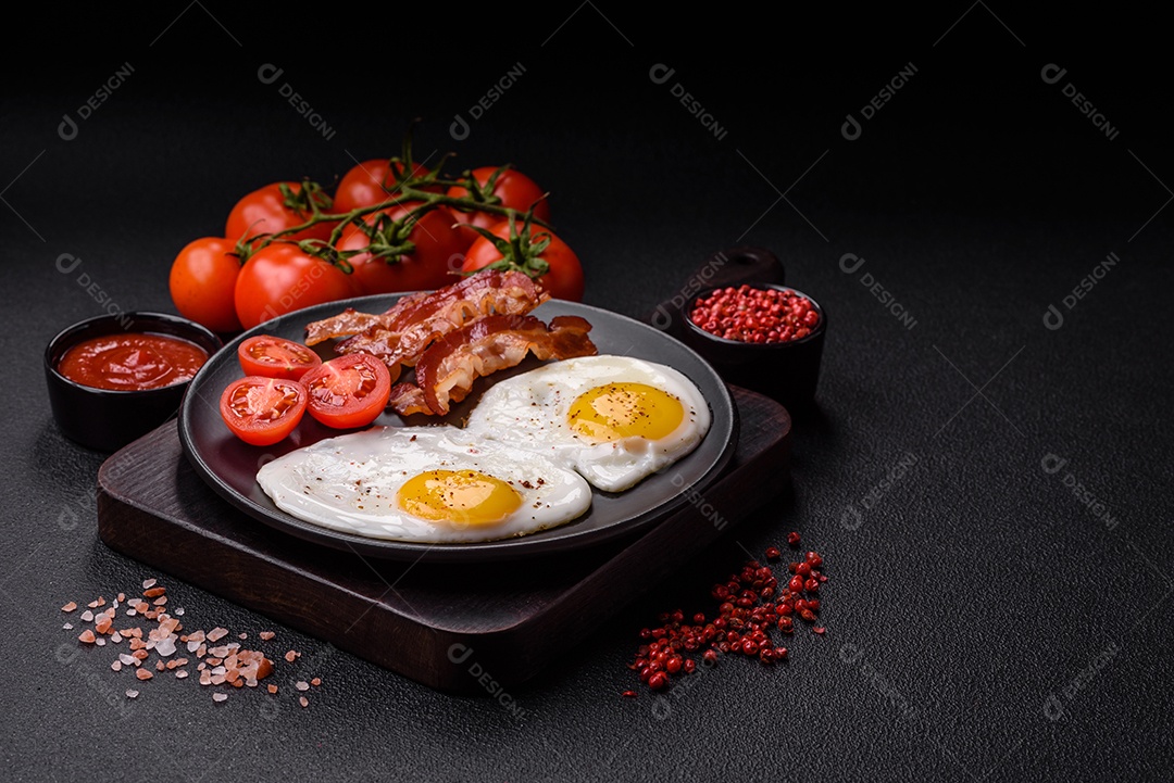 Café da manhã inglês com ovos fritos, bacon, feijão, tomate, especiarias e ervas. Um início de dia saudável e nutritivo