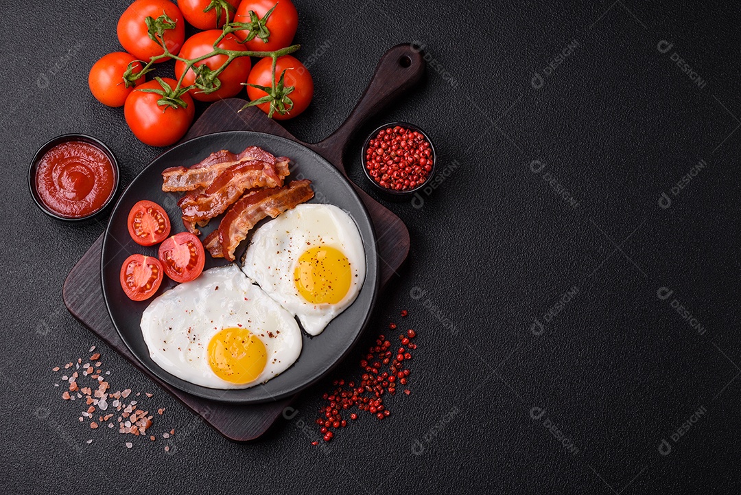 Café da manhã inglês com ovos fritos, bacon, feijão, tomate, especiarias e ervas. Um início de dia saudável e nutritivo