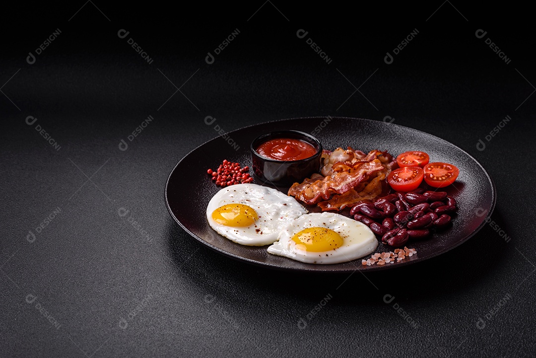 Café da manhã inglês com ovos fritos, bacon, feijão, tomate, especiarias e ervas. Um início de dia saudável e nutritivo