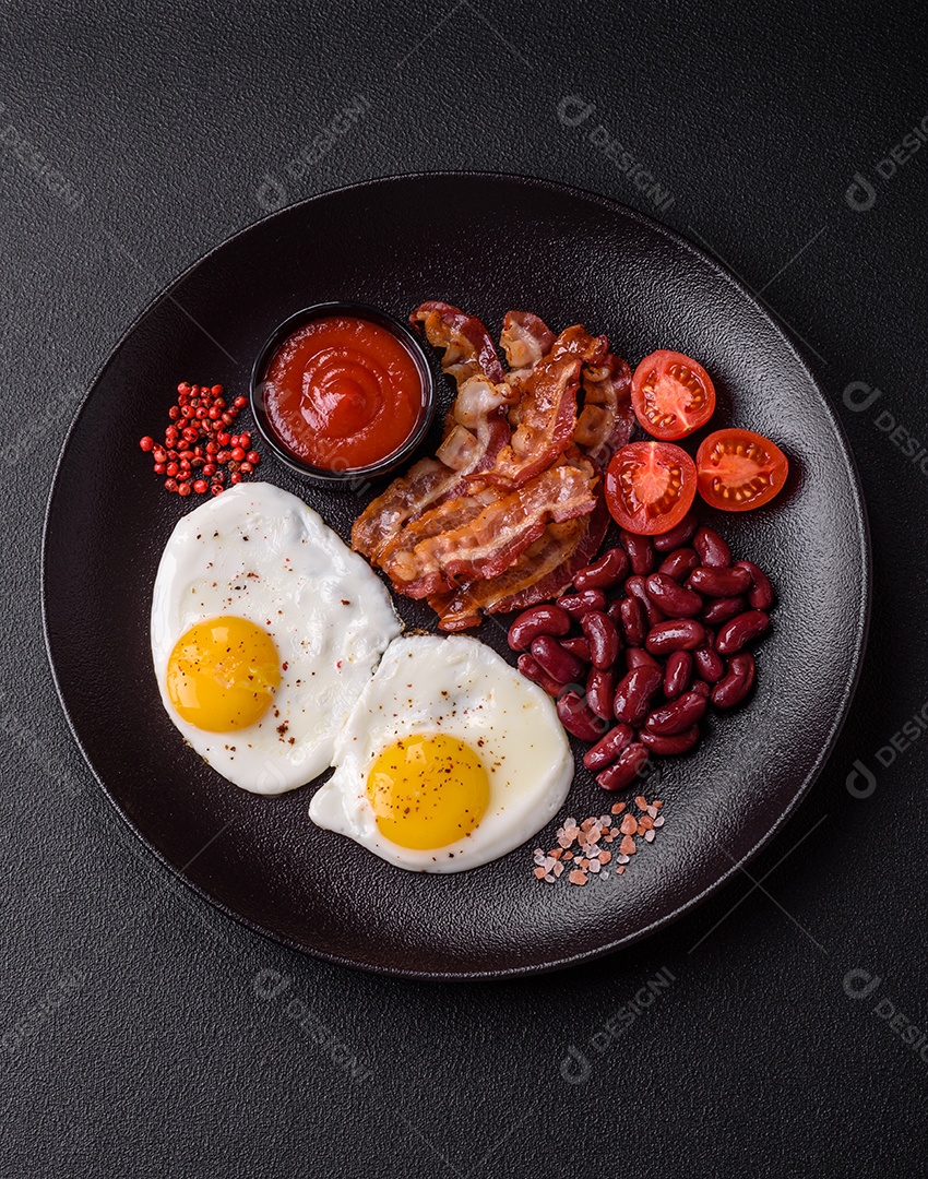 Café da manhã inglês com ovos fritos, bacon, feijão, tomate, especiarias e ervas. Um início de dia saudável e nutritivo