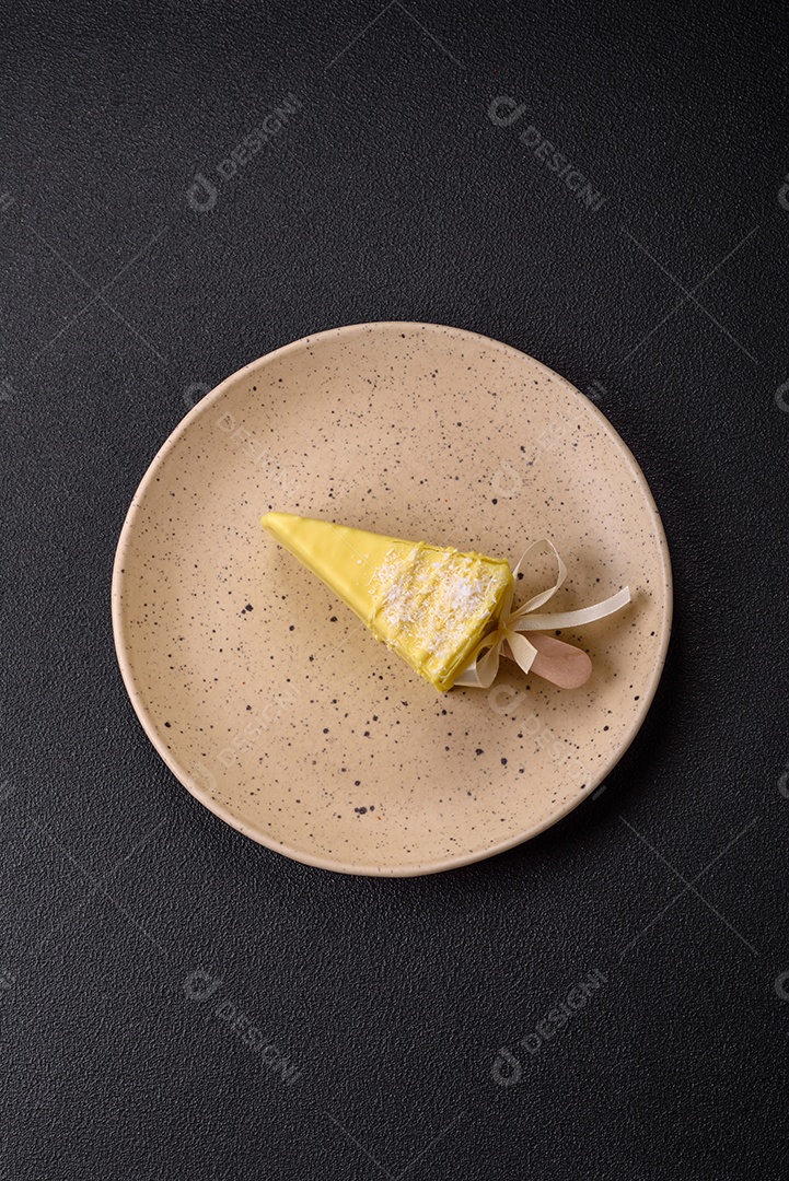 Delicioso cheesecake doce com frutas cobertas de glacê com uma vara de madeira sobre um fundo escuro de concreto