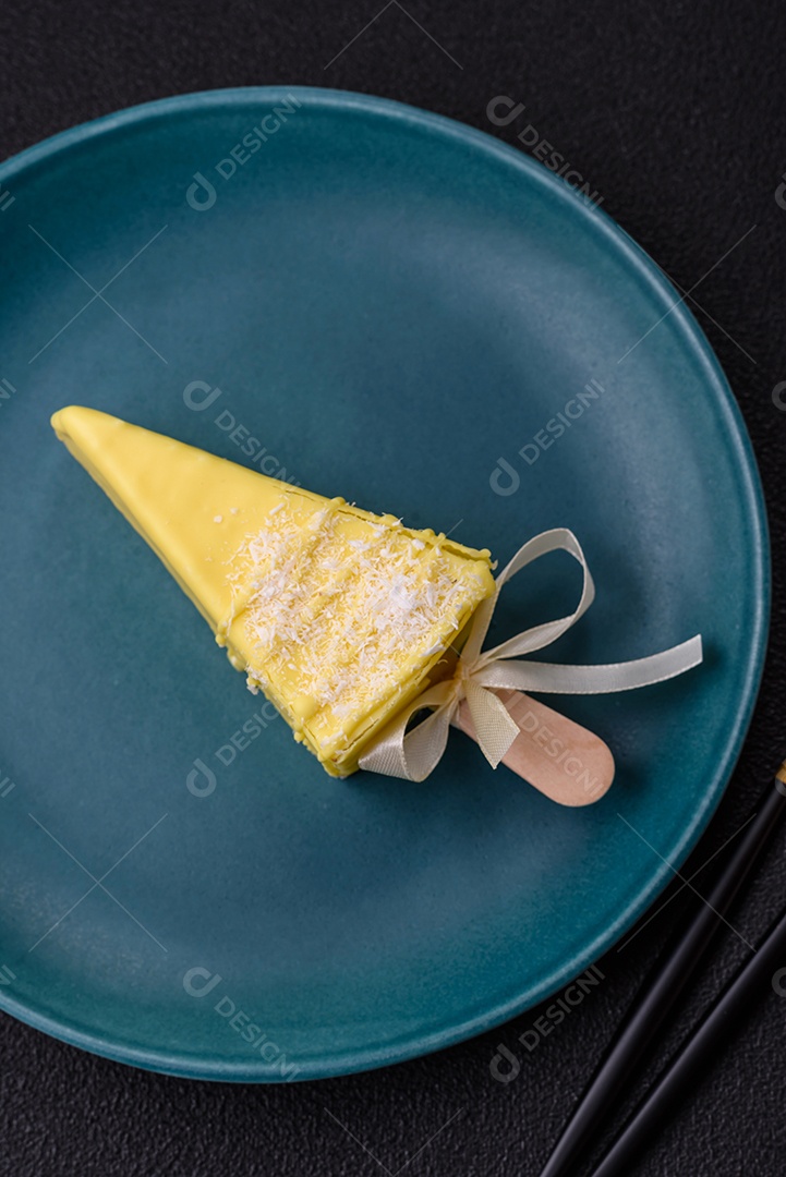 Delicioso cheesecake doce com frutas cobertas de glacê com uma vara de madeira sobre um fundo escuro de concreto