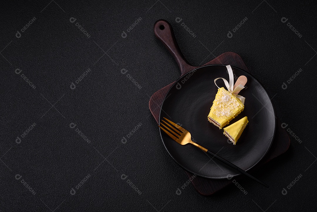Delicioso cheesecake doce com frutas cobertas de glacê com uma vara de madeira sobre um fundo escuro de concreto