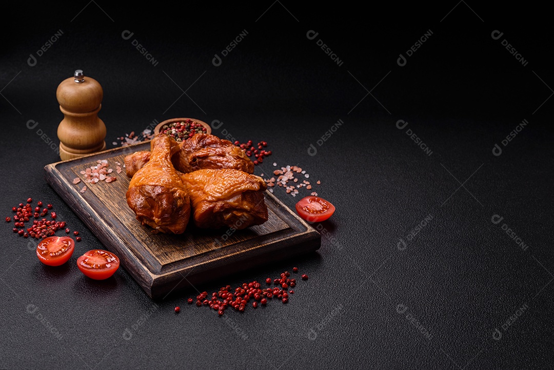 Deliciosas pernas de frango assadas na grelha com sal, especiarias e ervas sobre um fundo de concreto texturizado