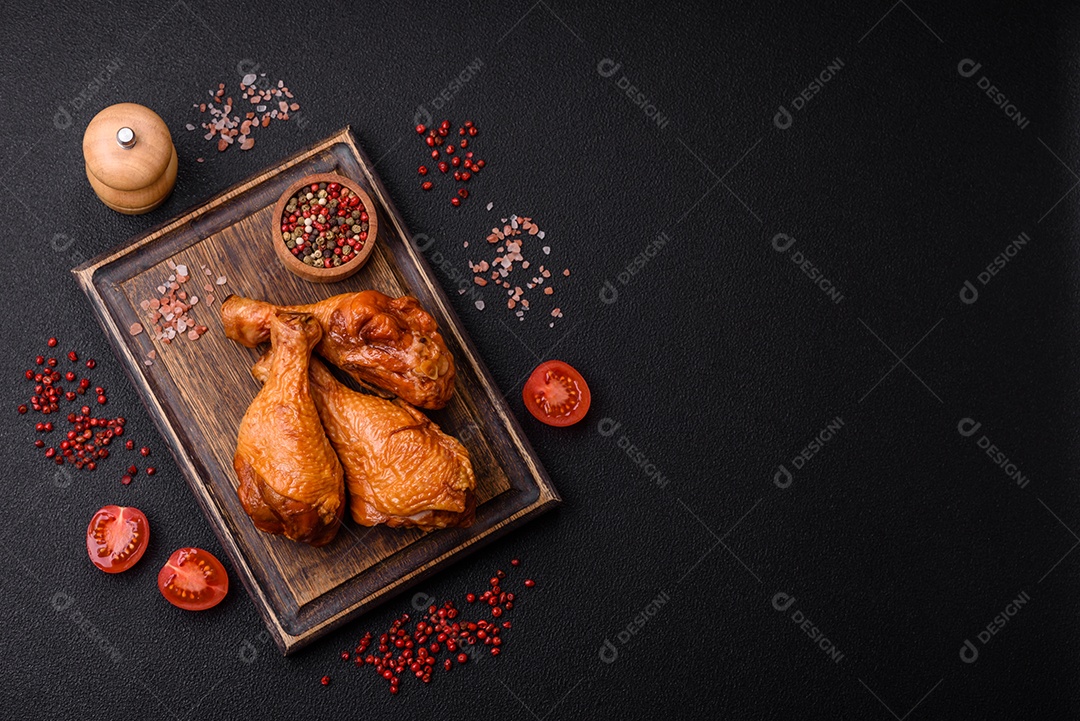 Deliciosas pernas de frango assadas na grelha com sal, especiarias e ervas sobre um fundo de concreto texturizado